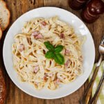 Top view of a plate of tagliatelli carbanara italian cuisine in a traditional restaurant setting